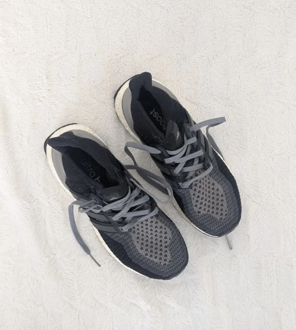 Zapatillas deportivas Adidas UltraBoost negras y grises de tela con cordones grises. Suela negra con detalles blancos. De running. La goma está un poco marcada, pero está impecable!