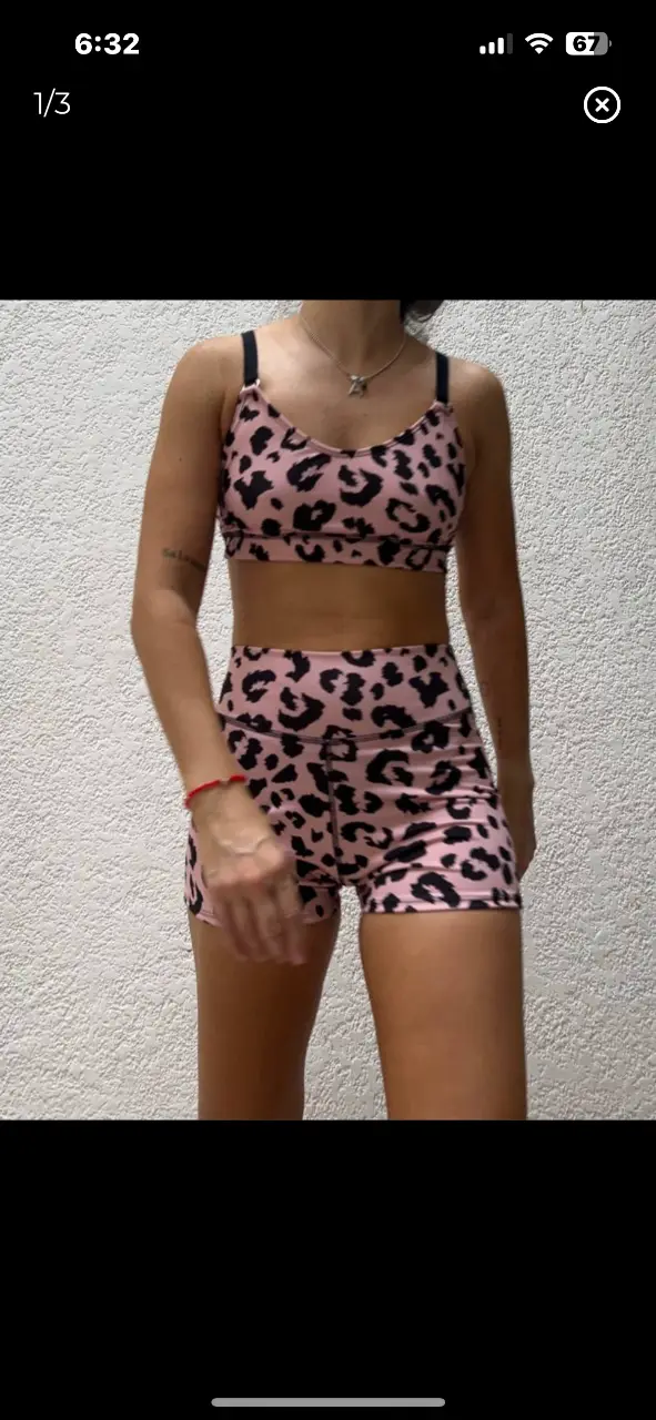 Conjunto deportivo de dos piezas con estampado de leopardo en tonos rosa y negro. Incluye un top deportivo con tirantes y shorts a juego, ideal para entrenamientos o actividades al aire libre.
