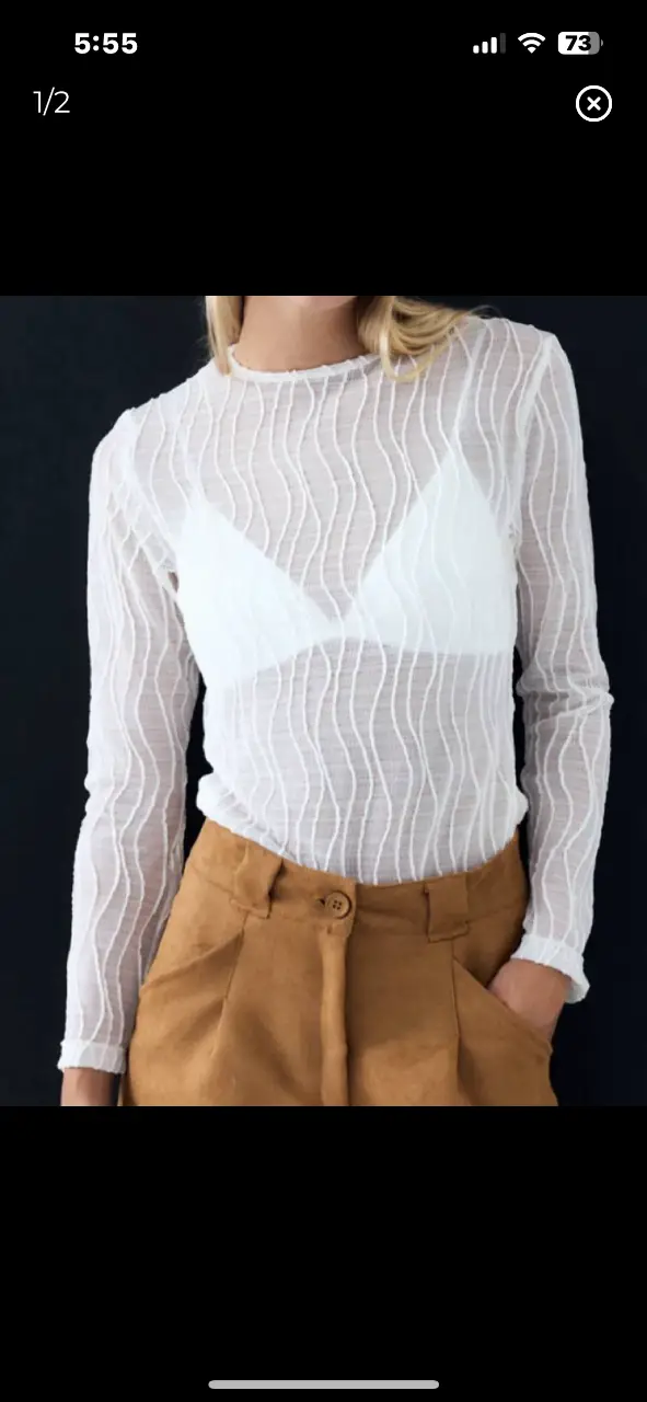 Blusa de manga larga transparente con diseño ondulado. Ideal para un look elegante y moderno. Perfecta para combinar con pantalones de vestir o faldas.