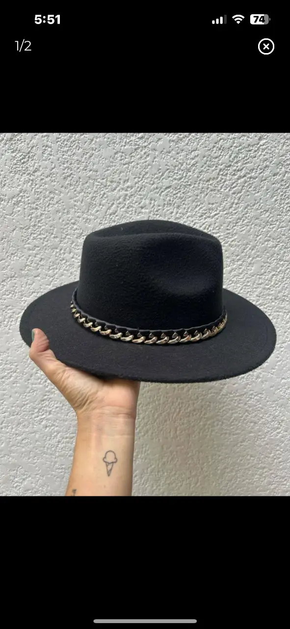 Sombrero negro con detalle de cadena dorada. Ideal para completar cualquier look con estilo y elegancia.