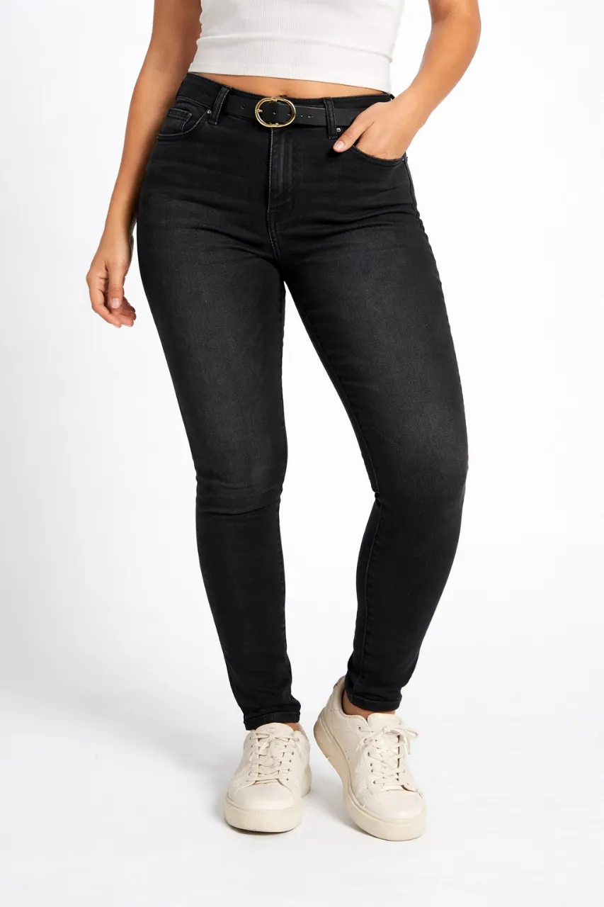 Jeans negros con detalles desgastados. Cierre y botón metálico.