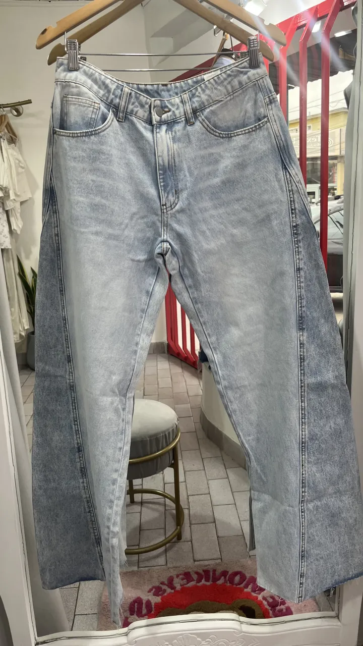 Jeans de tiro alto con lavado celeste y detalles desgastados en los laterales. Cierre con botón.