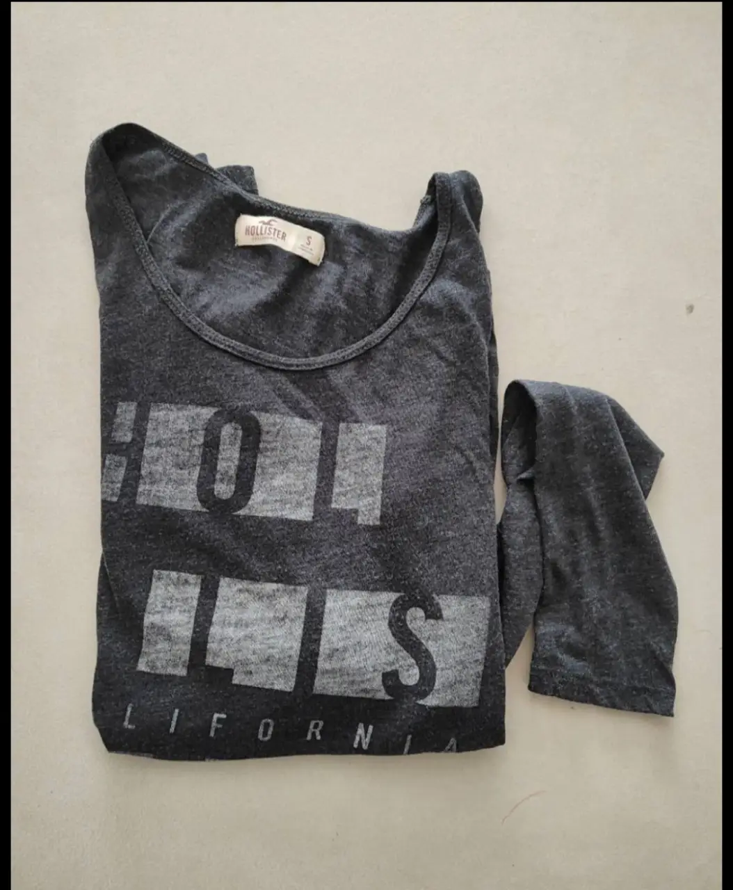 Musculosa gris con estampado "HOLLIS" y "CALIFORNIA". Ideal para un look casual y cómodo.