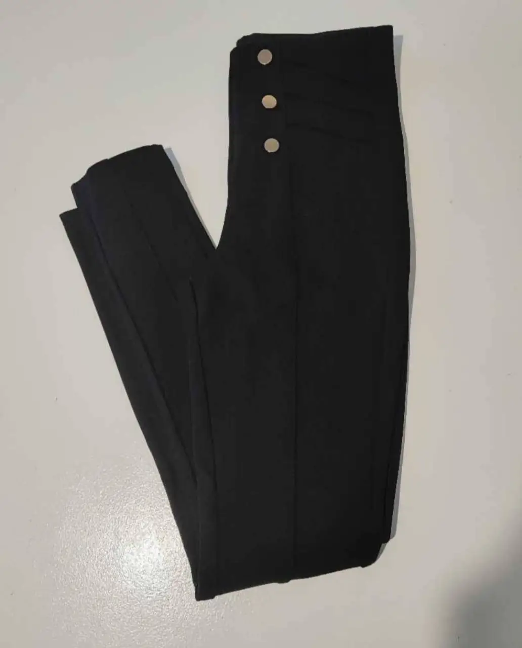 Pantalón sastrero negro de mujer, con detalles de botones dorados en la cintura. Talle XS, ideal para un look elegante y versátil.
