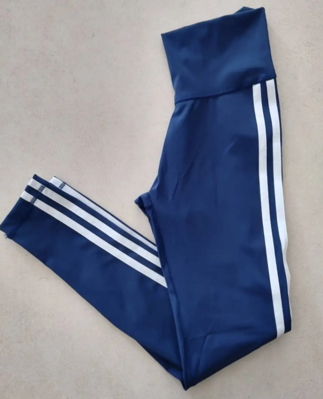 Calzas deportivas azules con tres tiras blancas en los laterales. Talle XS, ideales para entrenar o para un look casual.
