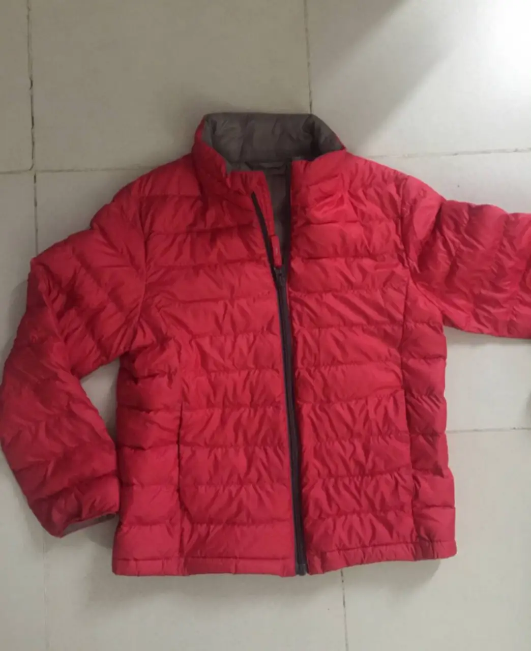 Campera de pluma roja, ideal para el invierno. Con cierre y cuello alto.