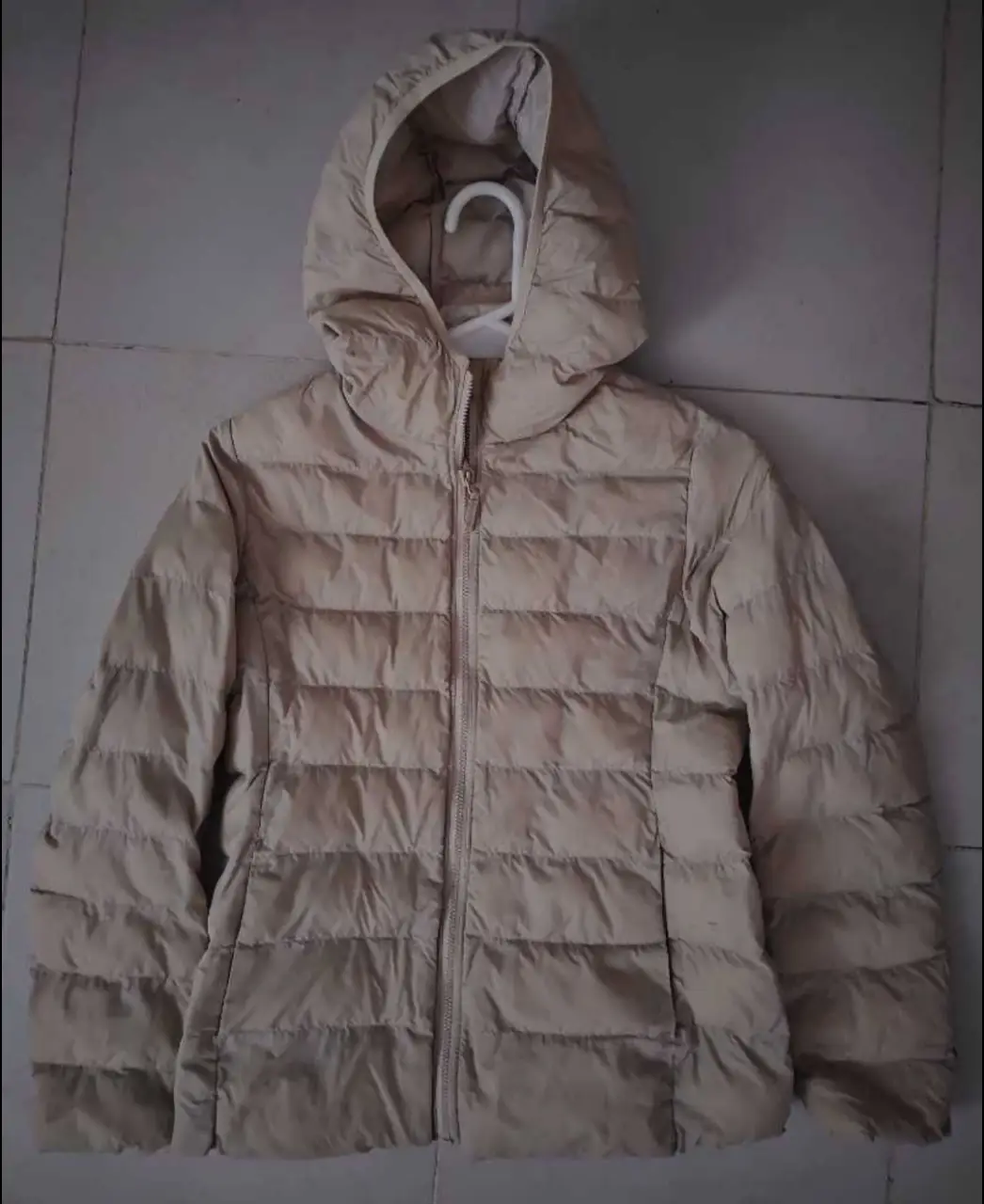 Campera de pluma Uniqlo para niña, color crudo, con capucha y cierre. Talle 150.