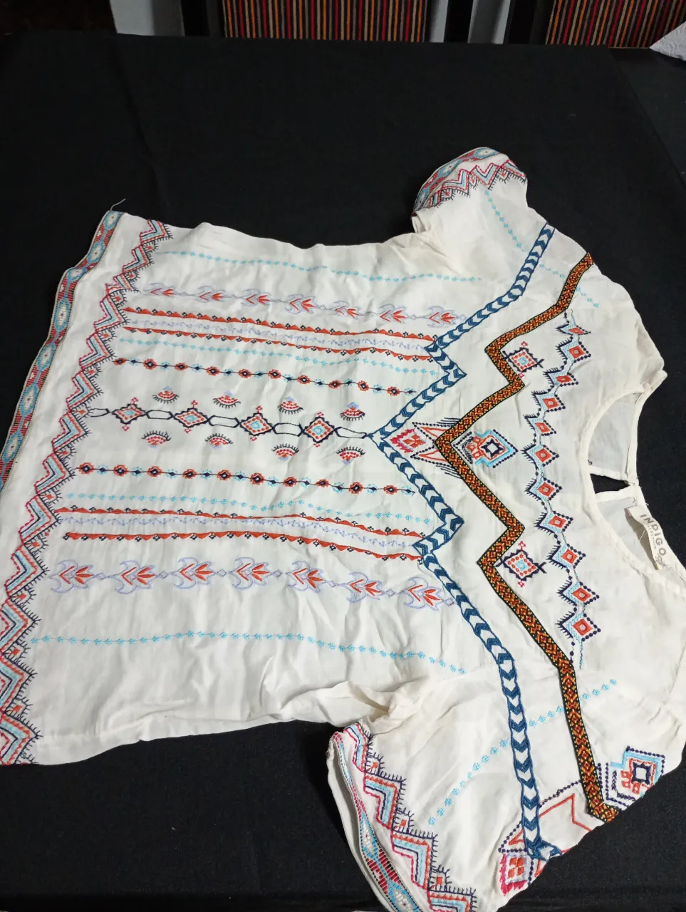 Blusa de mujer de color blanco con bordados en tonos rojo, azul y naranja. Estilo boho, ideal para un look casual y fresco.