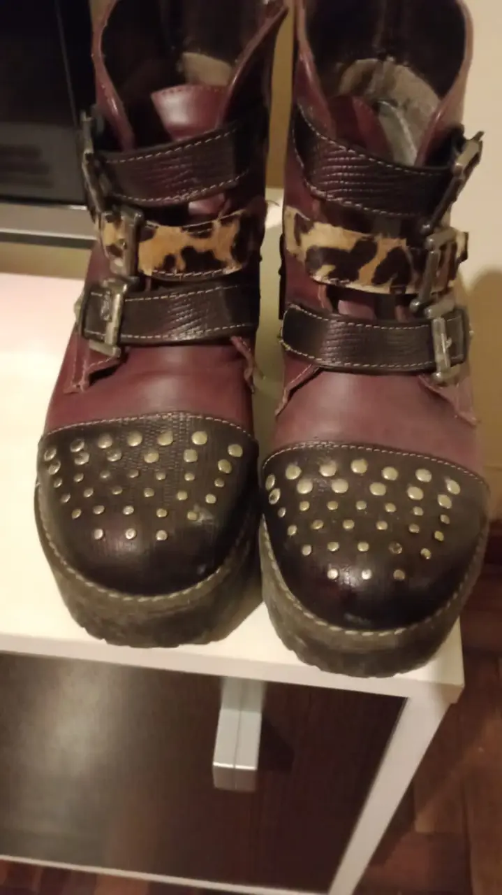 Botas de cuero con detalles de hebillas y apliques. Diseño rocker con detalles animal print y tachas en la puntera. Ideales para un look audaz y con estilo.