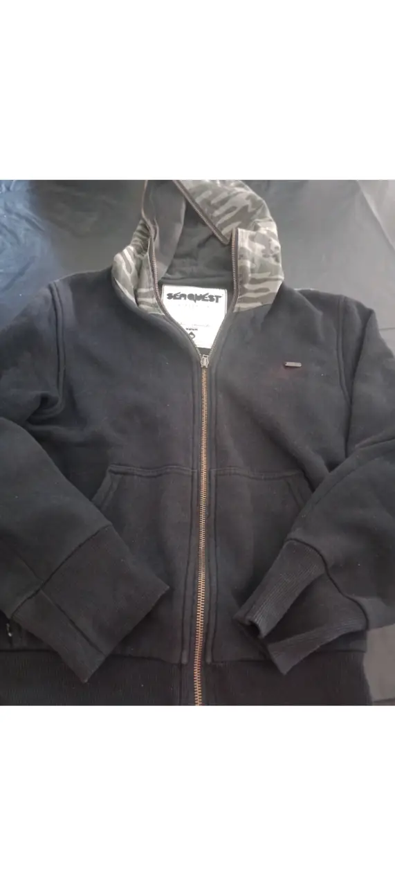 Buzo con cierre SeaQuest, con capucha y detalles camuflados. Ideal para un look casual y abrigado.