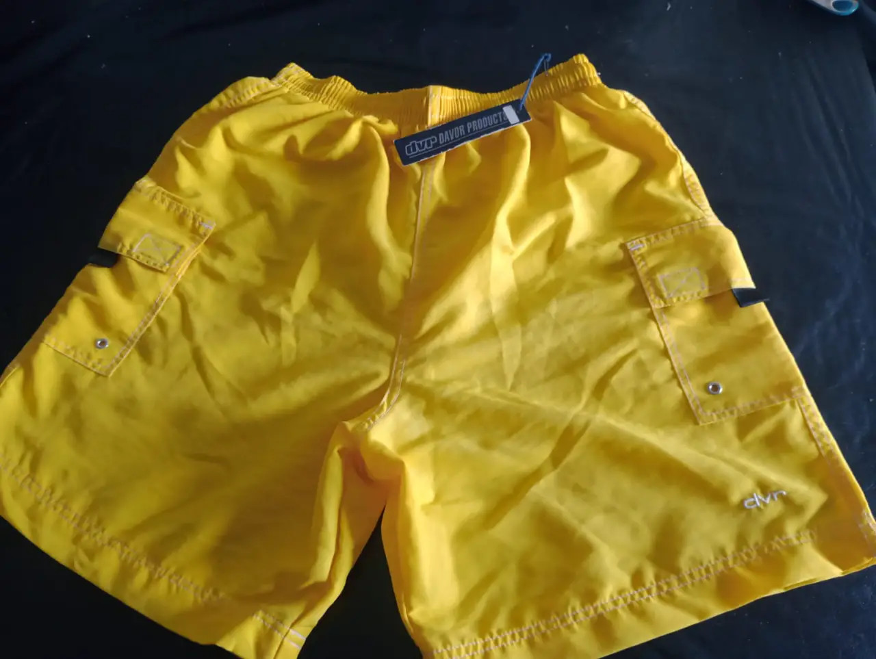 Short de baño sin uso  amarillo, ideal para actividades deportivas o para usar en la playa. Cuenta con bolsillos laterales y etiqueta de la marca.