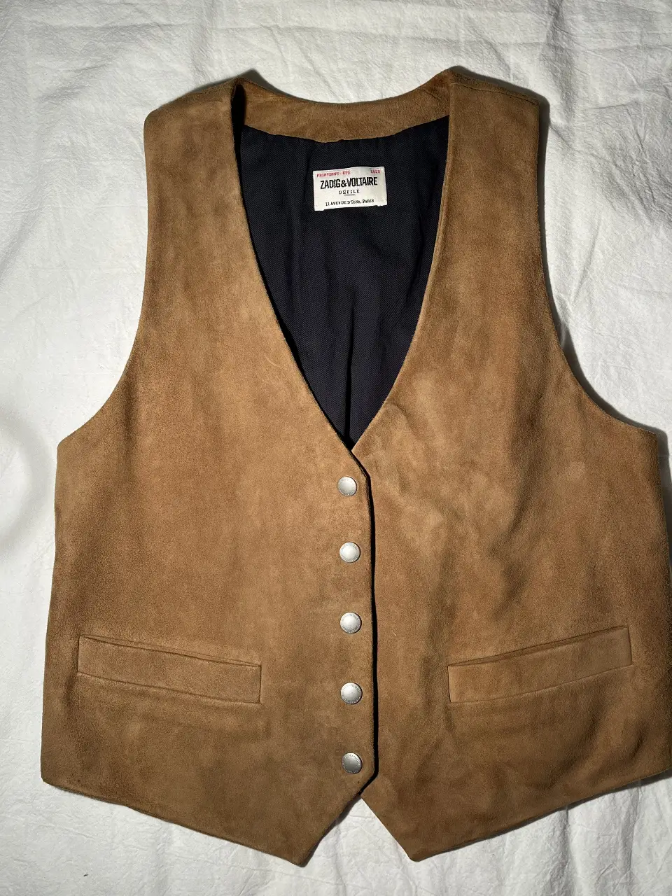 Chaleco de gamuza marrón de la marca Zadig & Voltaire. Tiene un diseño clásico con botones y dos bolsillos delanteros. Ideal para un look casual y elegante.