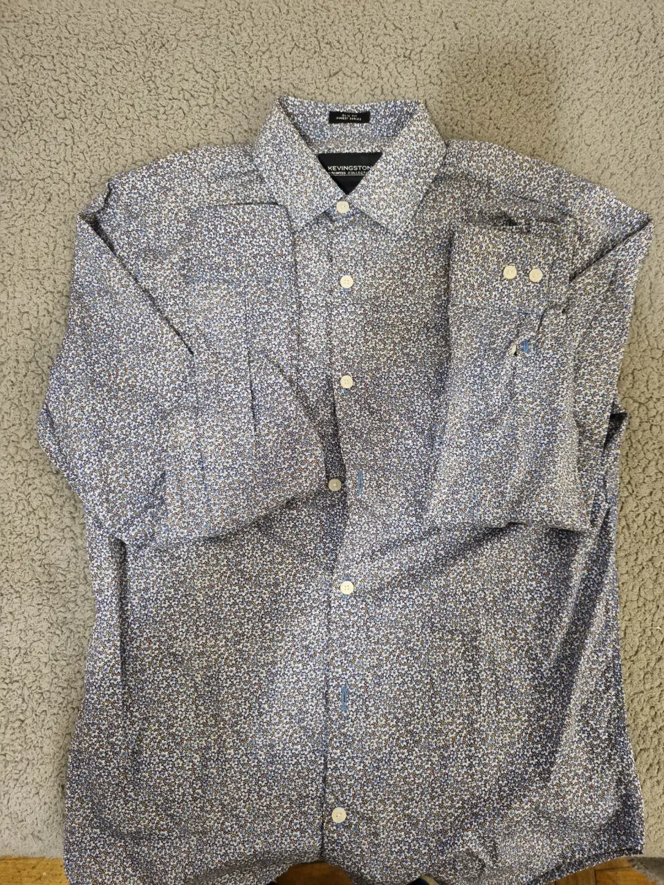 Camisa de hombre KEVINGSTON con estampado floral en tonos azules y blancos. Corte slim fit, ideal para un look casual o semi formal. Talle S.