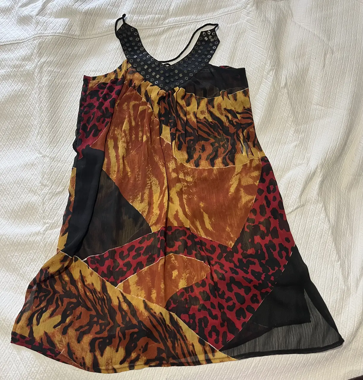 Vestido mini con estampado animal print y detalles en negro. Cuello halter con apliques. Ideal para una salida.