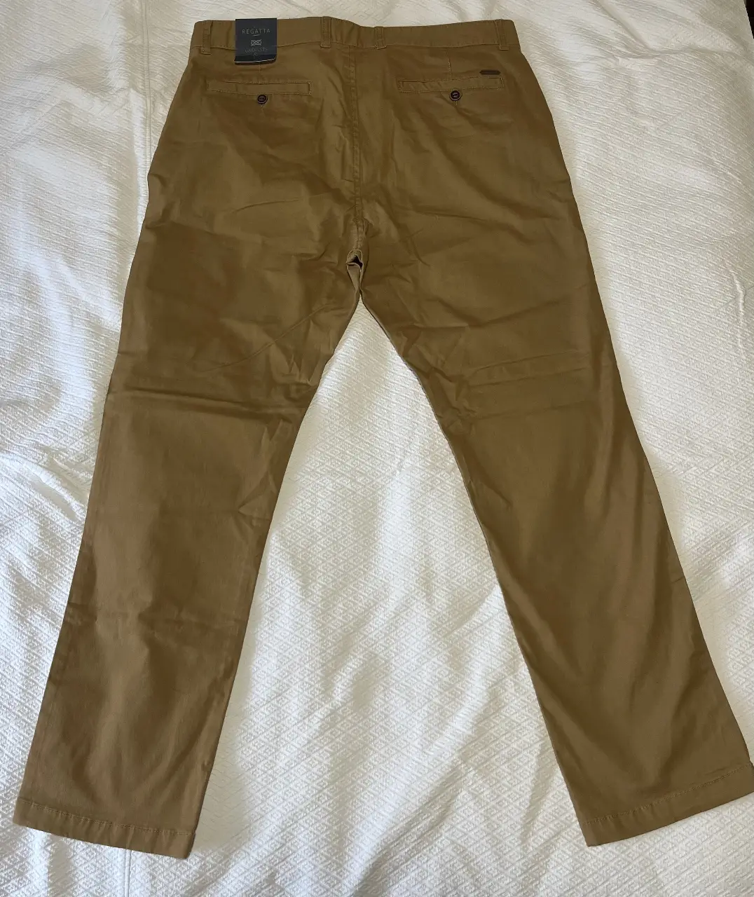 Pantalón chino de hombre, color marrón, corte recto, con etiqueta. Ideal para un look casual y cómodo.