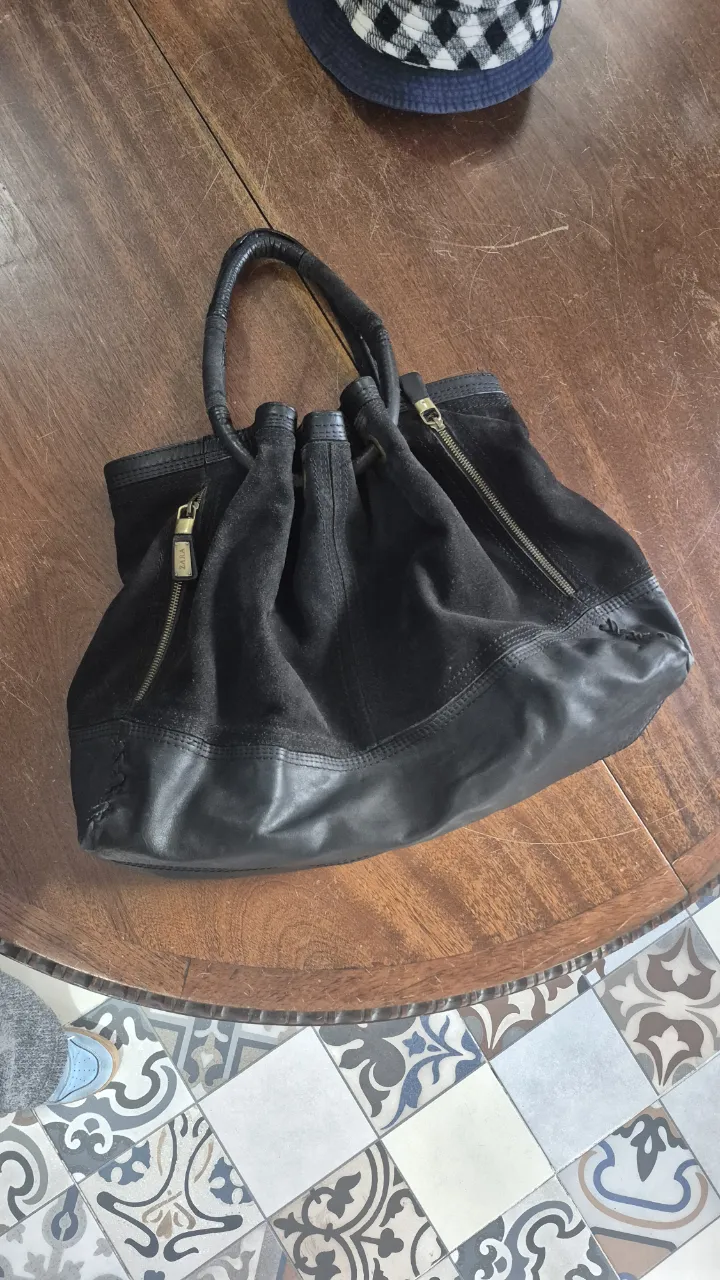Cartera negra de cuero y gamuza, con detalles de cierre y manijas. Zara