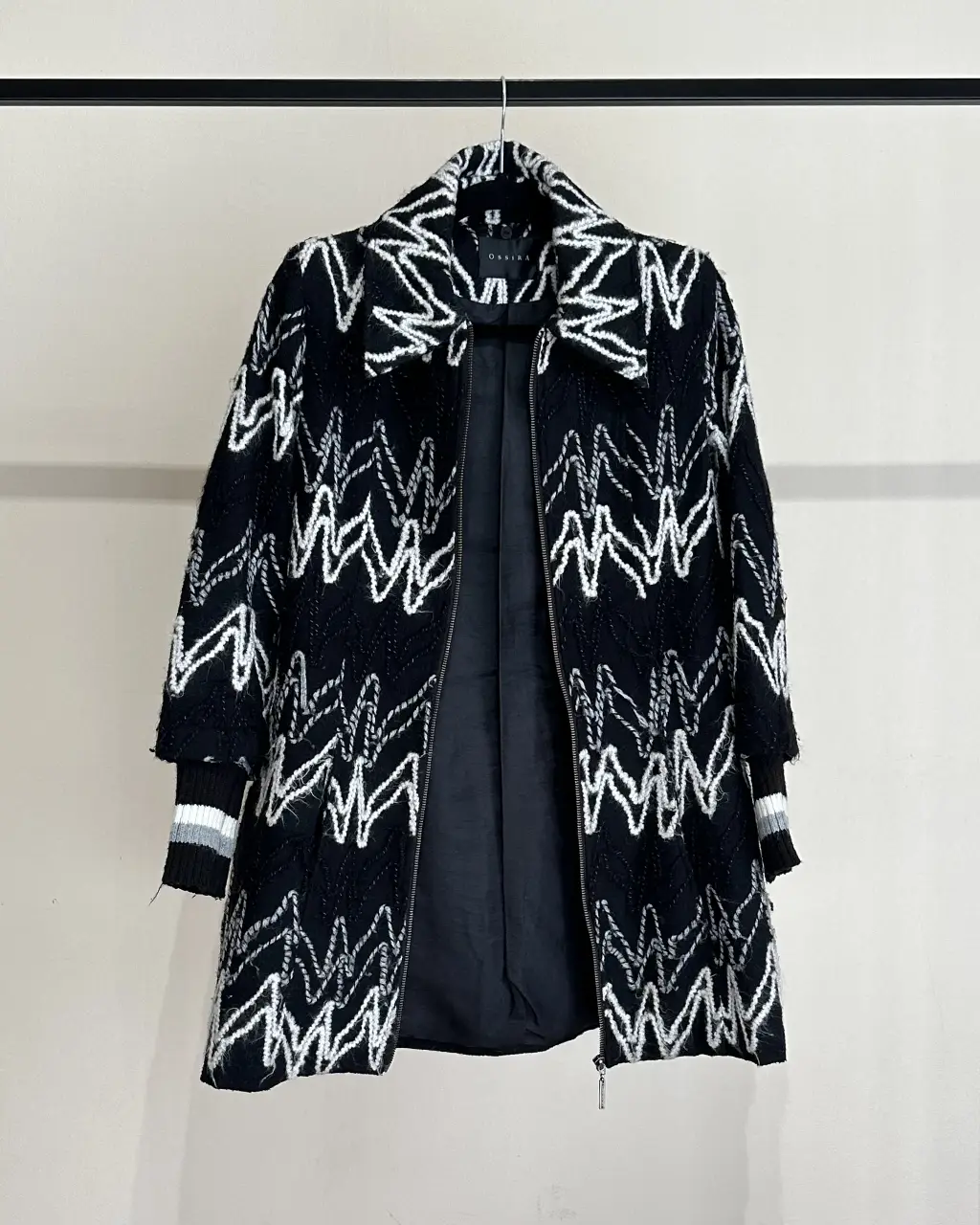 Tapado largo con estampado geométrico en blanco y negro. Mangas de rib al tono. Posee cierre y detalles en los puños. Ideal para un look de invierno E ir al trabajo o una salida nocturna.