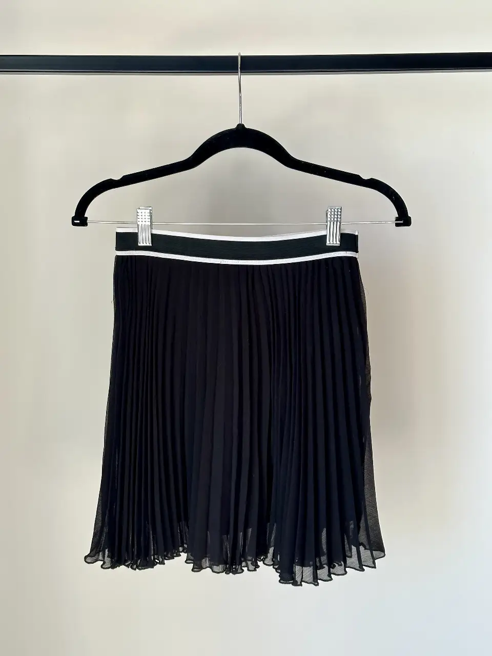 Pollera corta plisada de color negro (doble tela), con cintura elastizada con detalle blanco y negro. Ideal para un look elegante y sofisticado. Excelente estado, solo 2 usos. Largo: 42 cm.