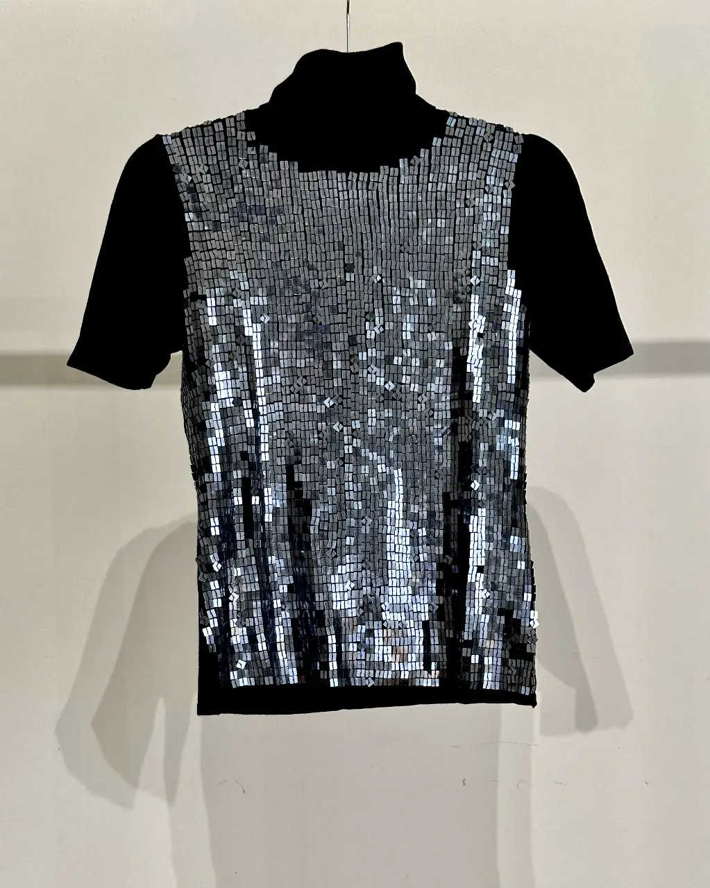 Sweater de cuello alto negro con frente de lentejuelas plateadas. Ideal para un look de fiesta o salida. Excelente calidad. 