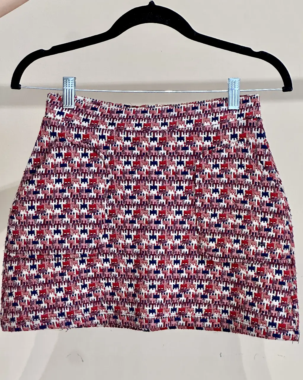 Pollera tipo lanilla con estampado geométrico en tonos rojos, blancos y azules e hilos metalizados. Ideal para un look casual ya que tiene bolsillos o para combinar con una blusa elegante. Cintura: 34 cm aprox (tiene elástico). Largo: 34 cm.