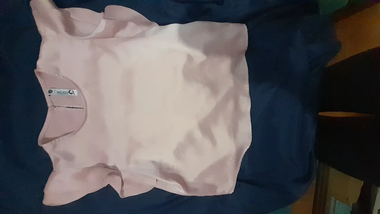 Blusa de mujer color rosa claro con detalles de volados en las mangas. Ideal para un look elegante y femenino.