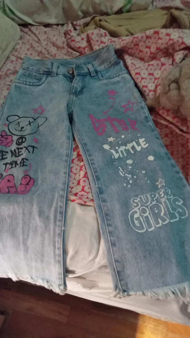 Jeans de mujer tiro alto con diseño de dibujos y frases en rosa y blanco. Corte recto con terminación desflecada.