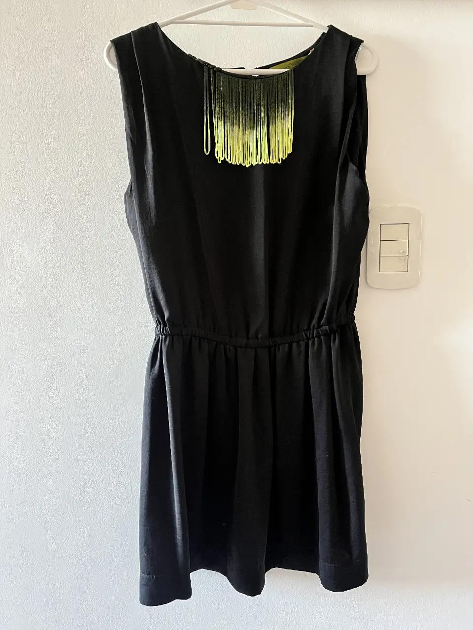 Vestido midi negro con detalle de flecos en el cuello. Ideal para una salida o evento especial. Marca Rapsodia.