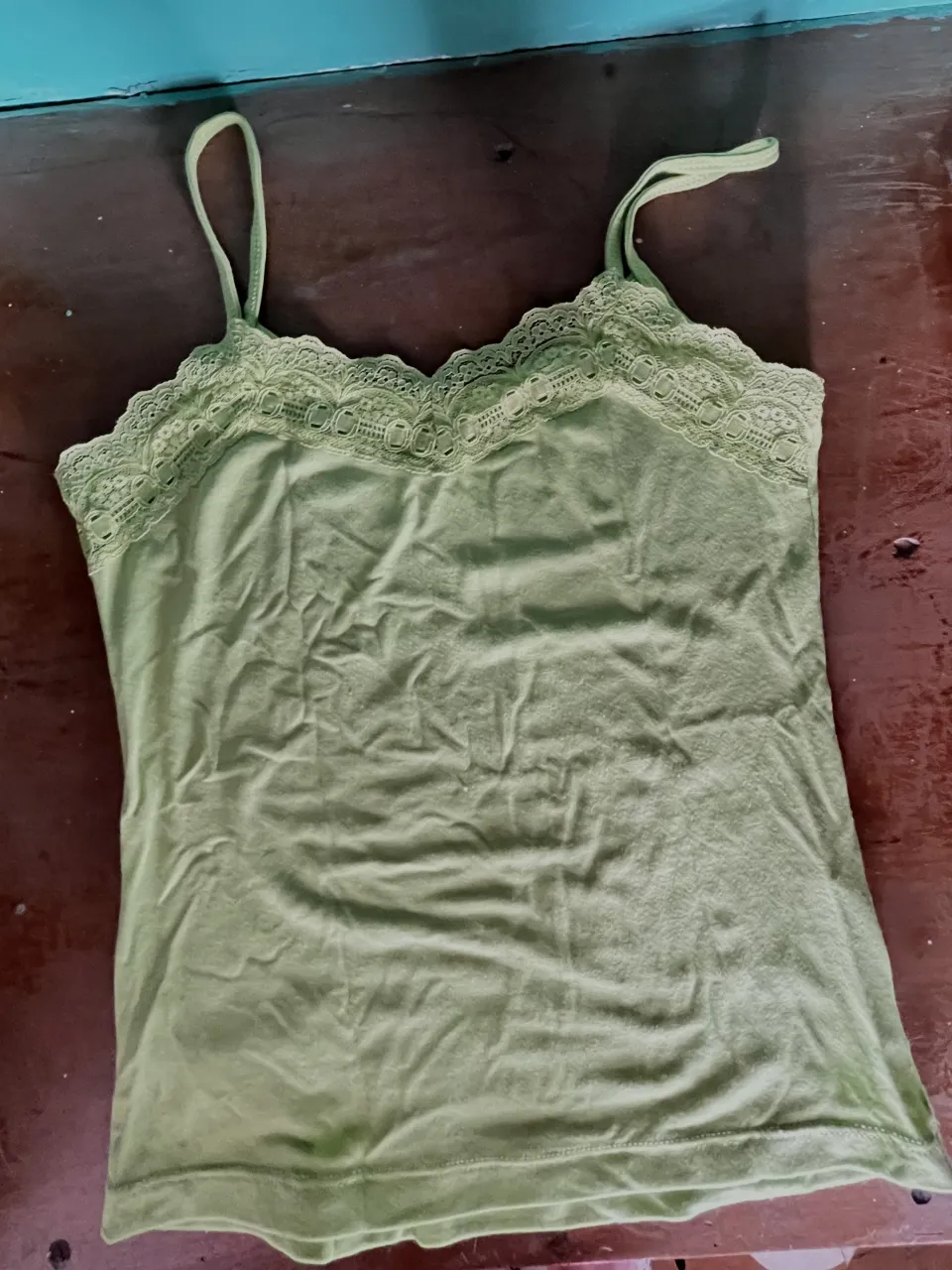 Musculosa verde con detalles de encaje en el escote.