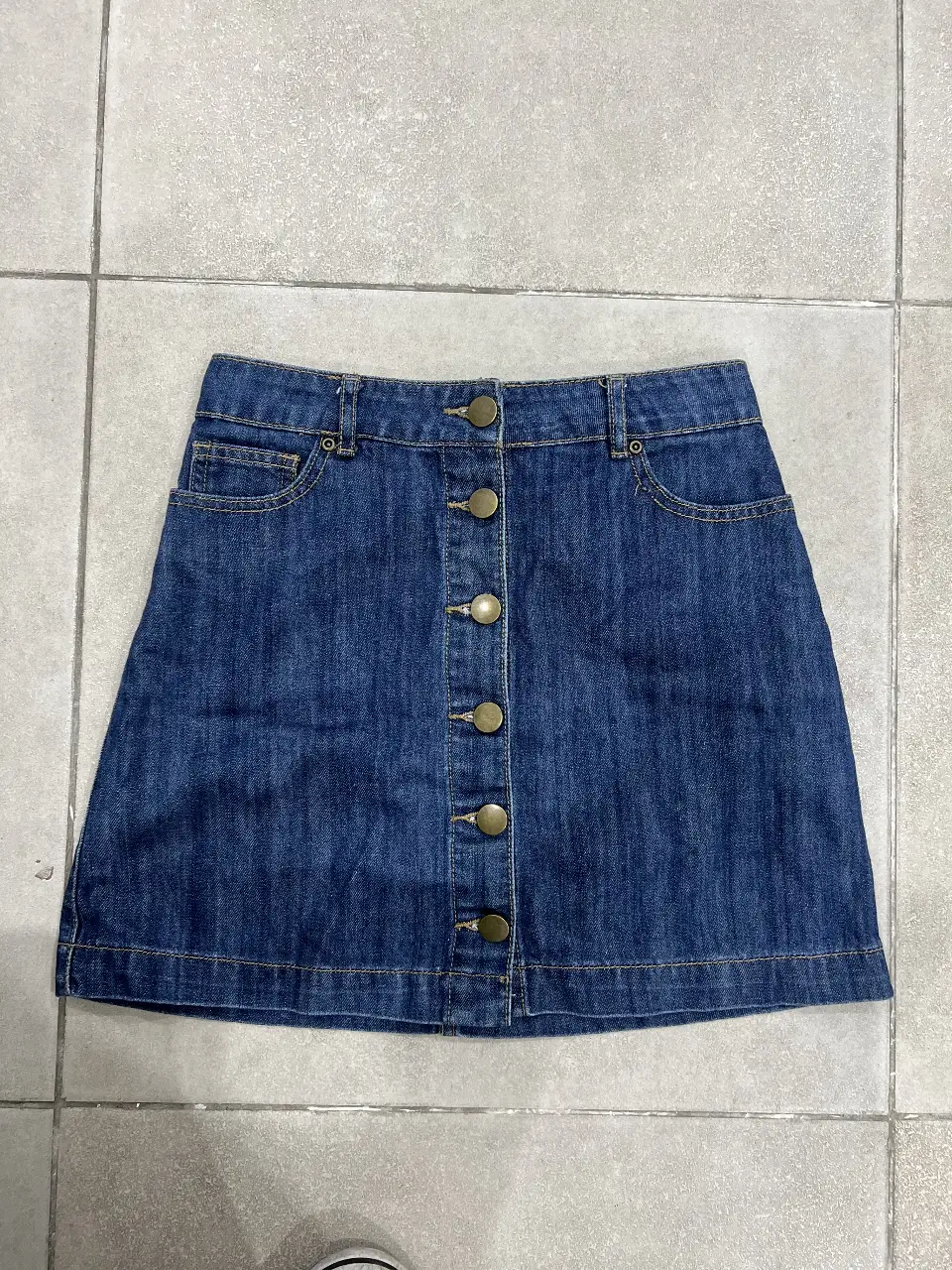 Pollera larga de jean azul con botones delanteros. Ideal para un look casual y versátil.