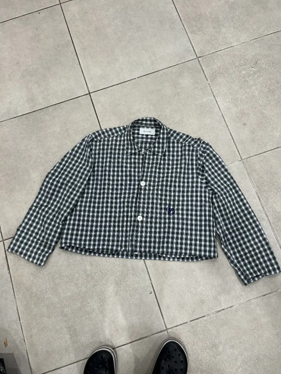 Camisa a cuadros verde y blanca, de manga larga, con botones y cuello. Ideal para un look casual y moderno.