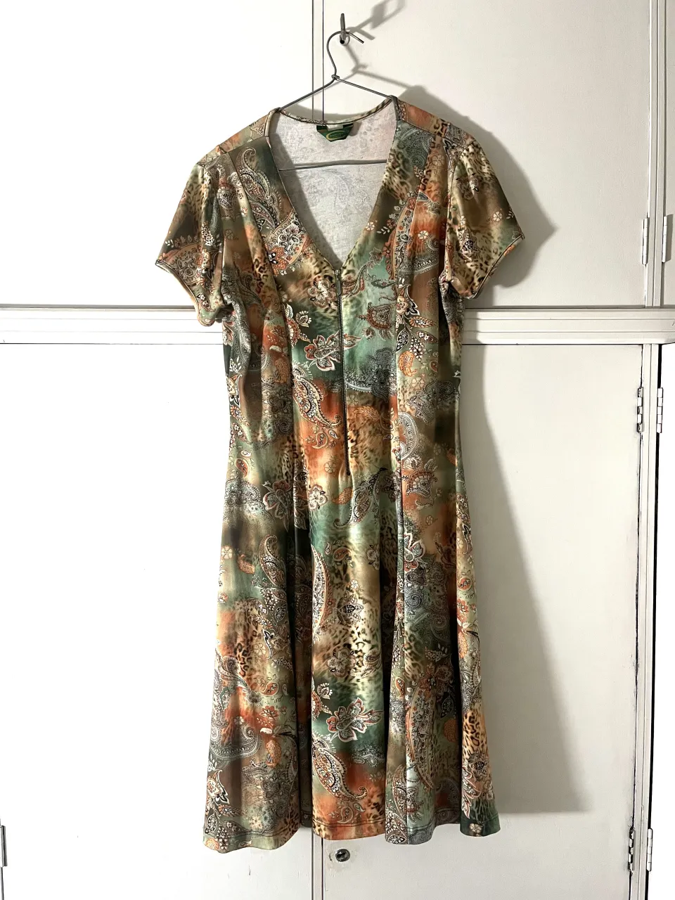 Vestido estampado con cuello en V y cierre al frente. Posee mangas cortas.