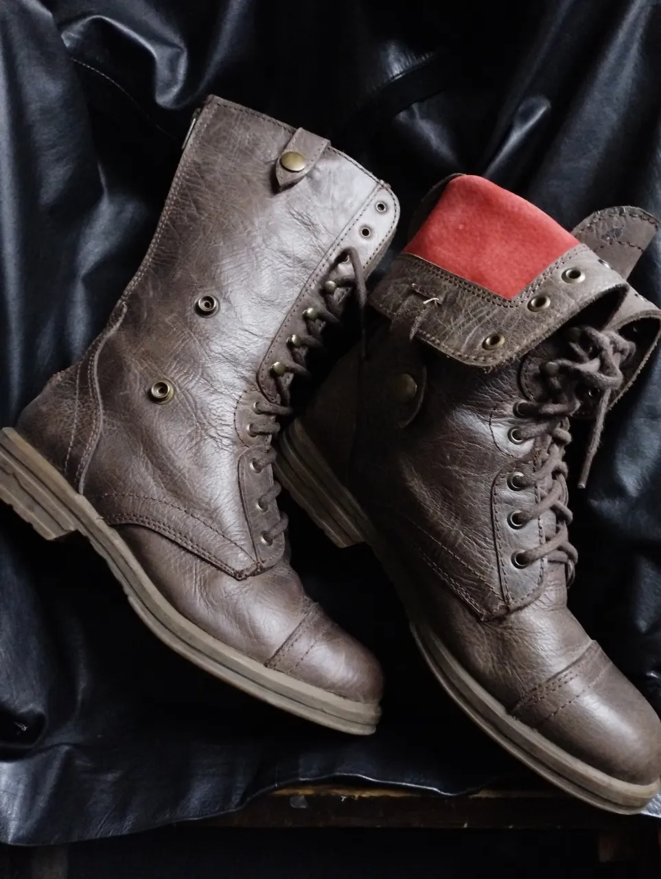Borcegos marrónes con detalles de color rojo  y cordones. Se puede doblar en la parte superior. Ideales para un look casual y con estilo.
