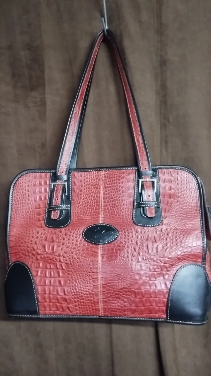 Cartera de mano roja con textura de cocodrilo y detalles en negro. Ideal para un look elegante y sofisticado.