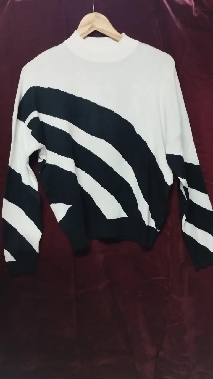 Sweater media polera con diseño a rayas diagonales en blanco y negro. Ideal para un look moderno y abrigado. Hilo y elastizado.
