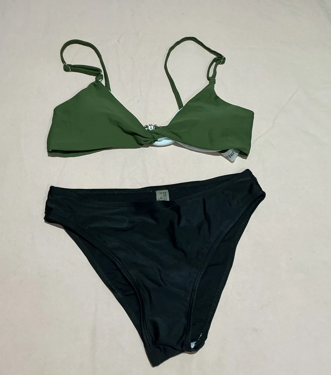 Bikini de dos piezas, corpiño verde con detalle de nudo y bombacha negra. Ideal para disfrutar del sol y el mar.