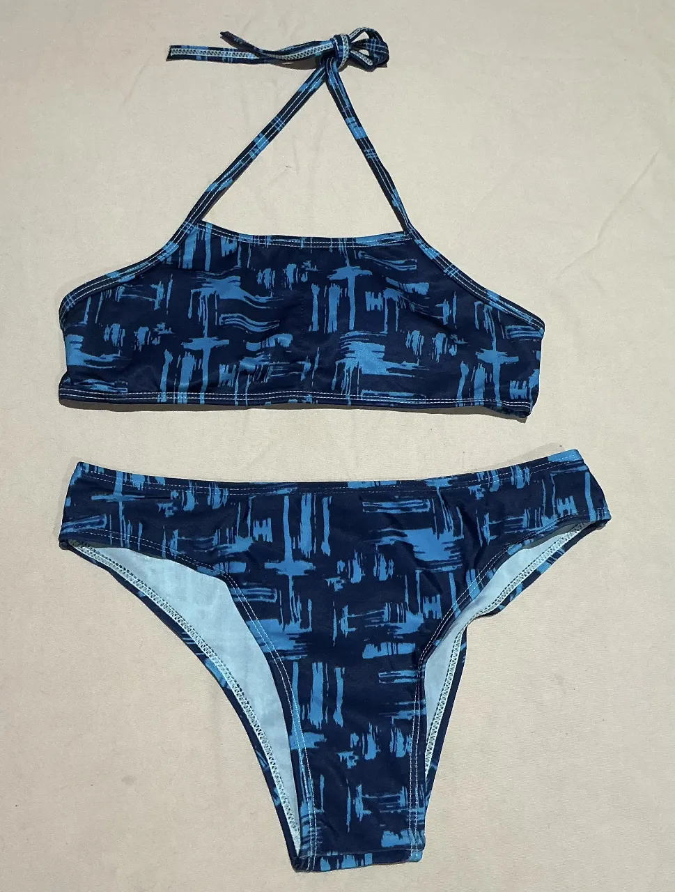 Bikini estampada en tonos azules y negros. Modelo con corpiño tipo halter y bombacha colaless. Ideal para disfrutar del verano y la playa.