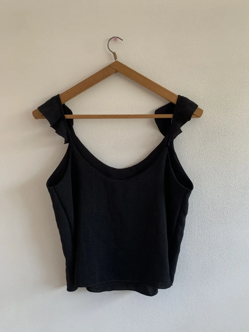 Musculosa negra con breteles finos y detalle de volados en los hombros. Nueva