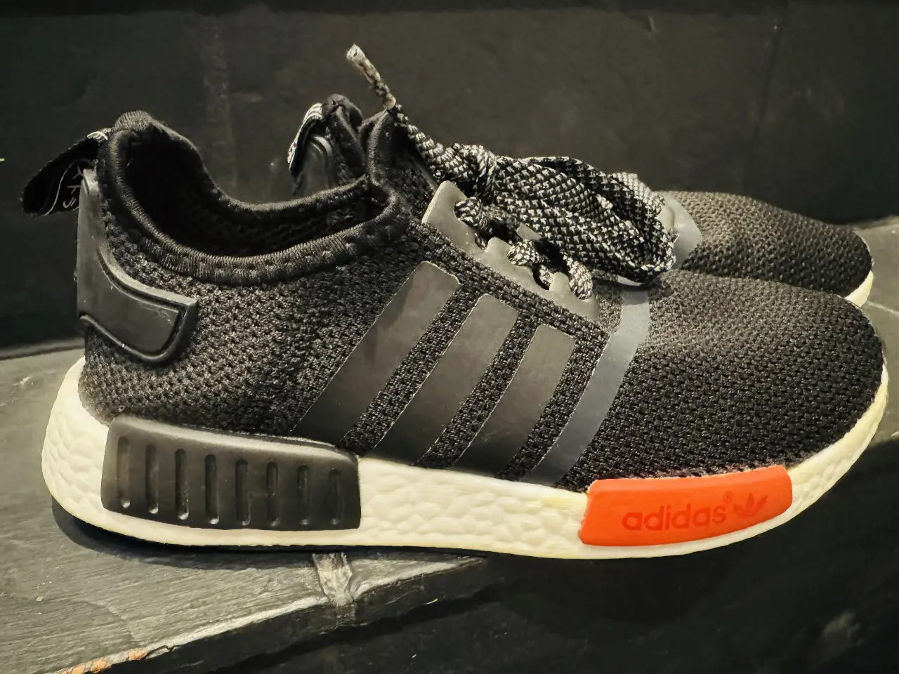 Zapatillas Adidas NMD negras con detalles en blanco y rojo. Ideales para un look urbano y deportivo.
