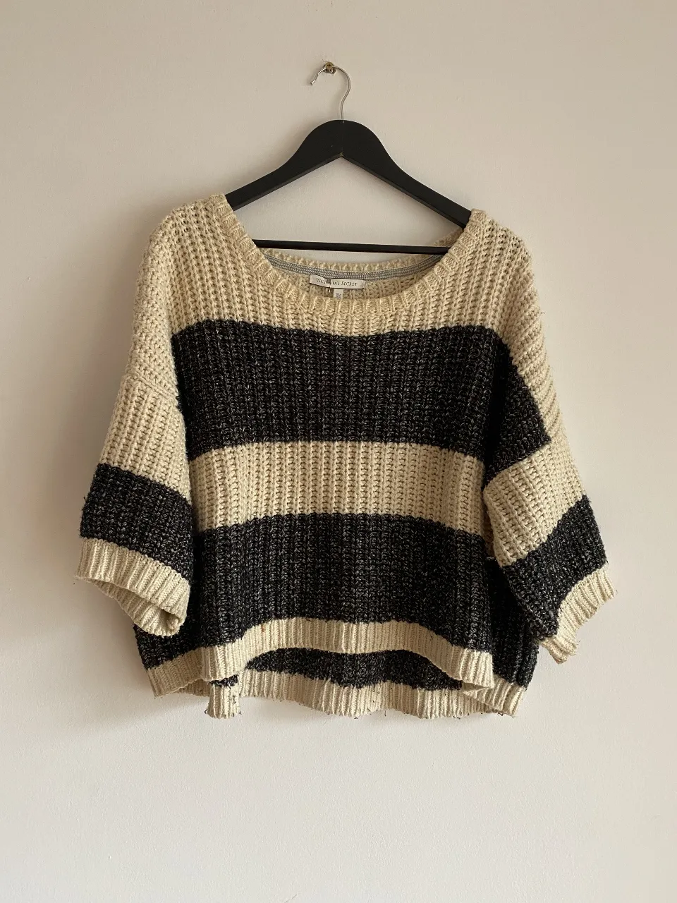 Sweater de tejido grueso a rayas horizontales en color crudo y negro. Cuello redondo y mangas 3/4.
