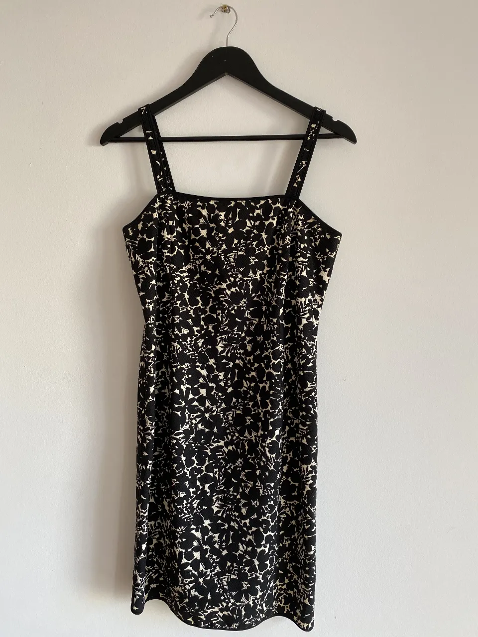 Vestido mini con estampado floral en blanco y negro, con tirantes finos y corte recto. Ideal para una salida o evento casual.