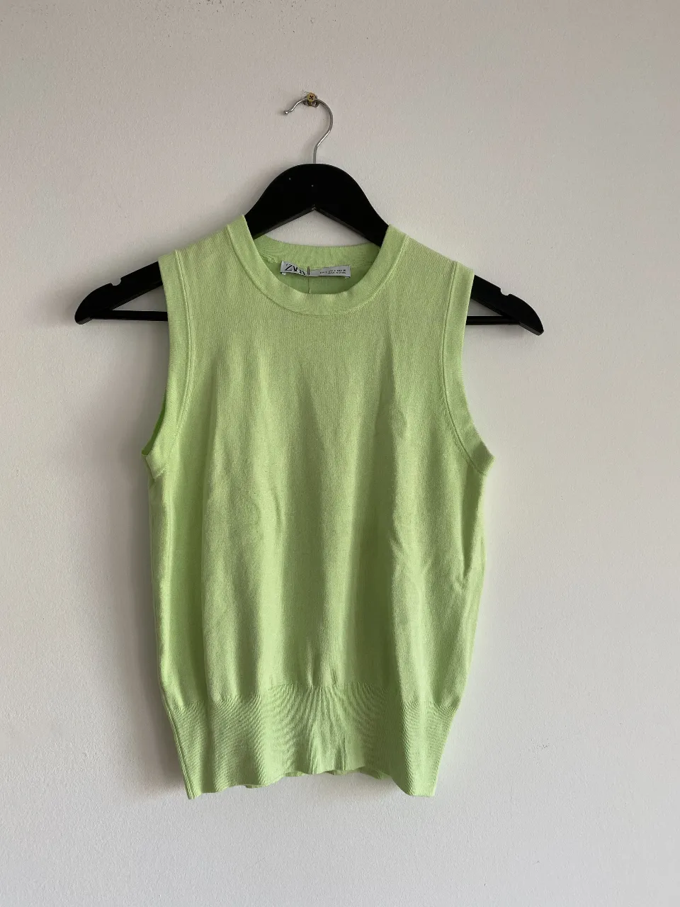 Musculosa de tejido de punto en color verde claro, ideal para un look fresco y casual. Perfecta para combinar con jeans o shorts.
