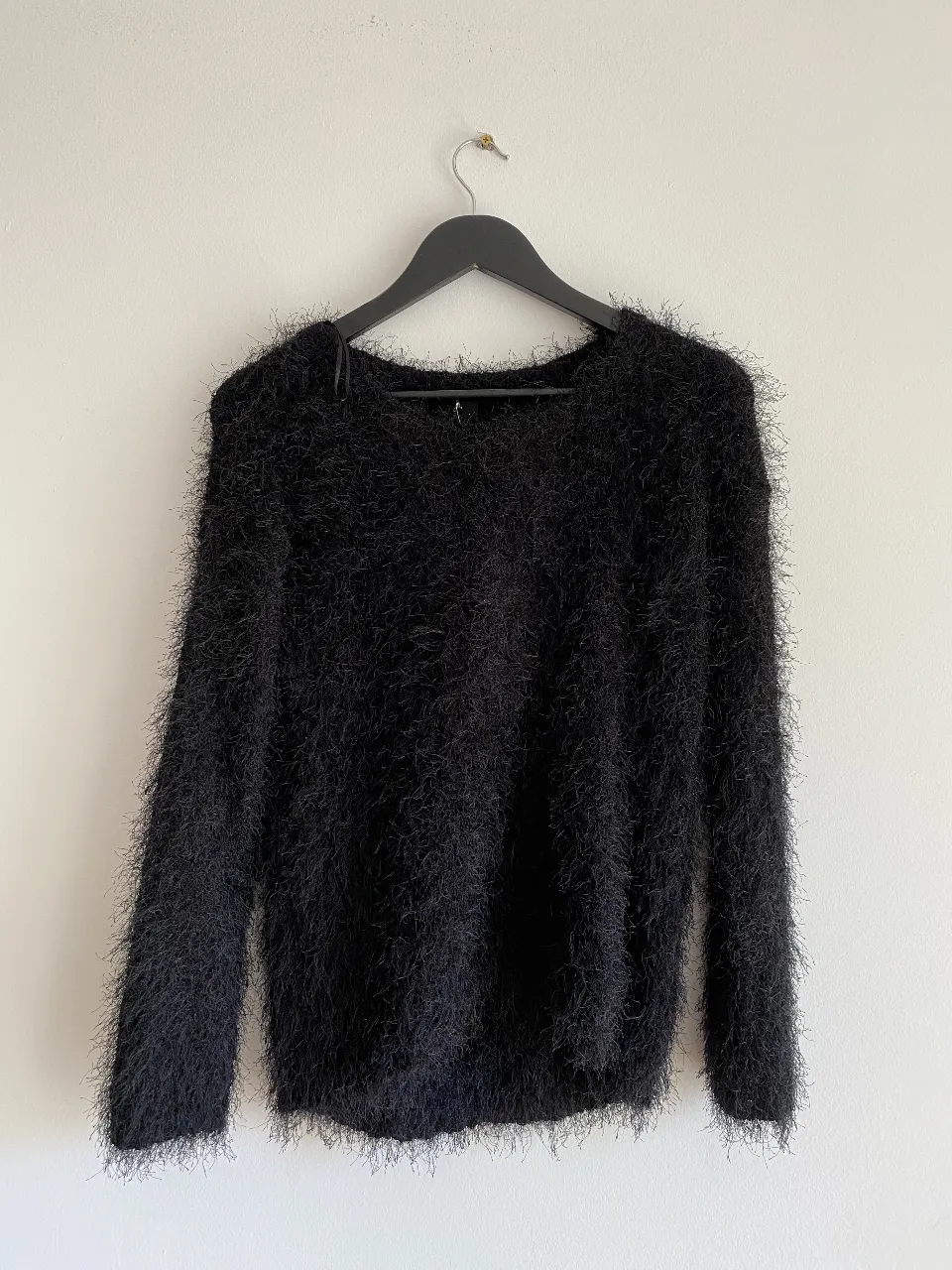 Sweater largo de mujer, color negro, con textura peluda. Ideal para un look de invierno.