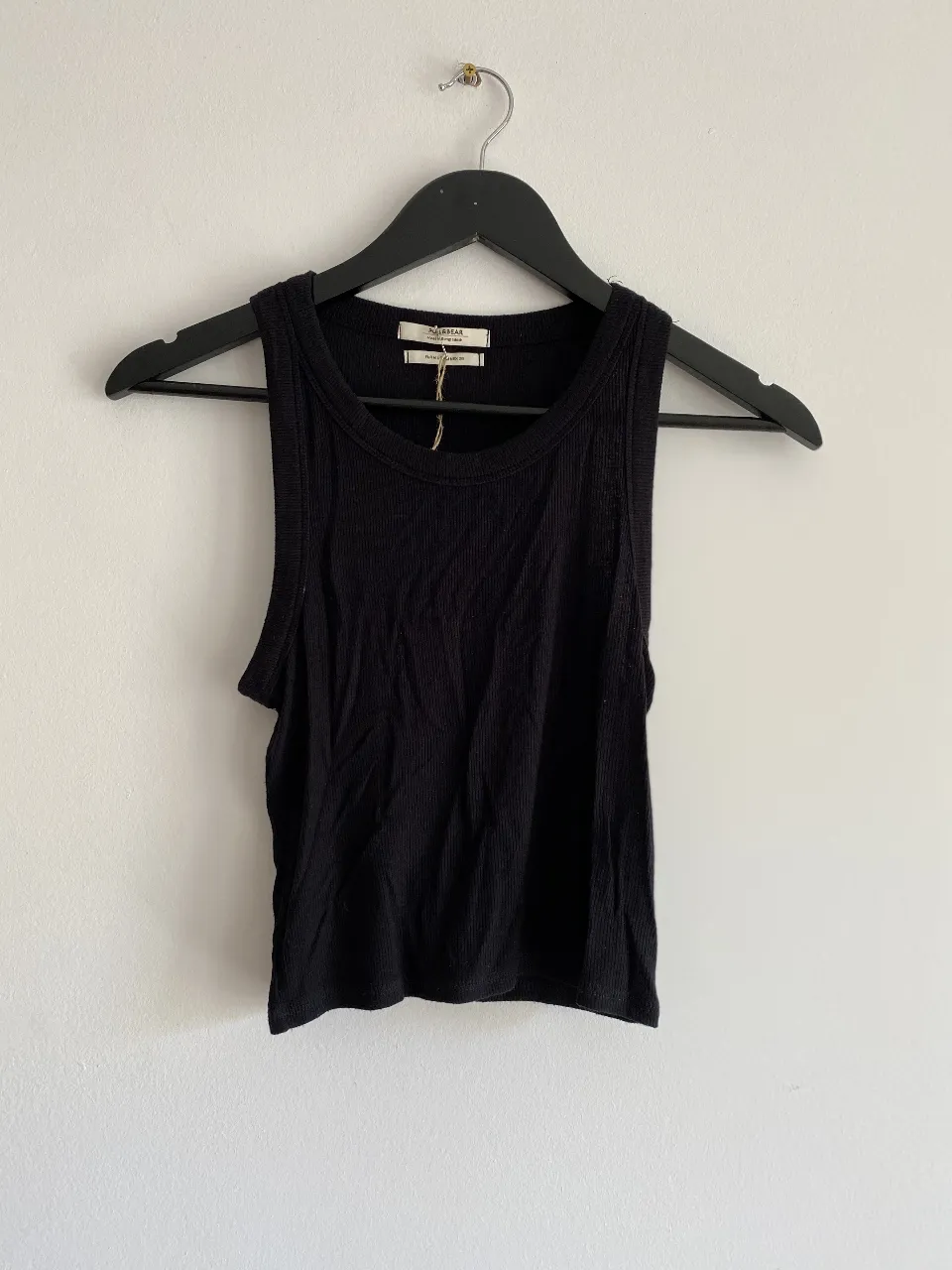 Musculosa negra de tejido acanalado, ideal para un look casual y cómodo.