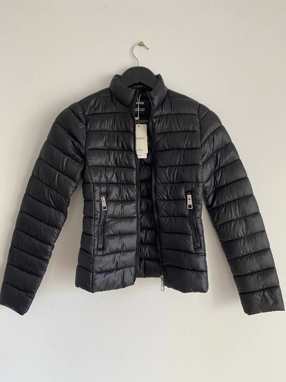 Campera de pluma negra, ideal para el invierno. Con cierre y bolsillos laterales. Marca Mango.