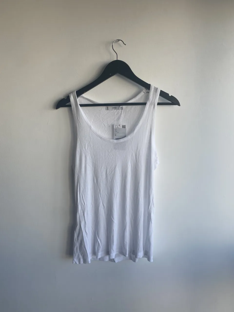 Musculosa blanca lisa con cuello redondo.
