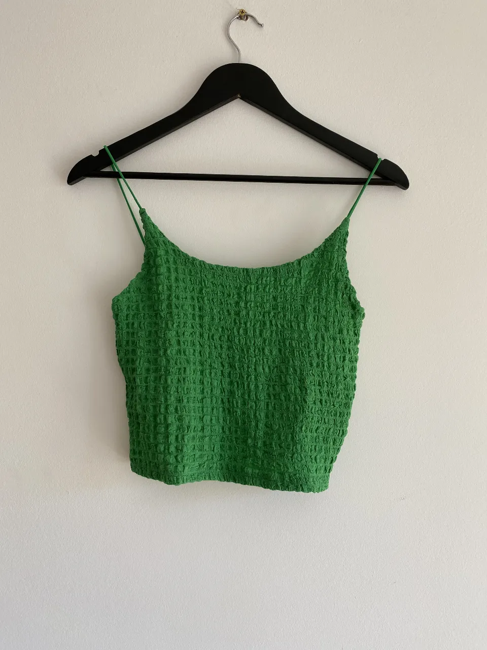 Top verde con breteles finos y textura waffle. Ideal para un look fresco y canchero.