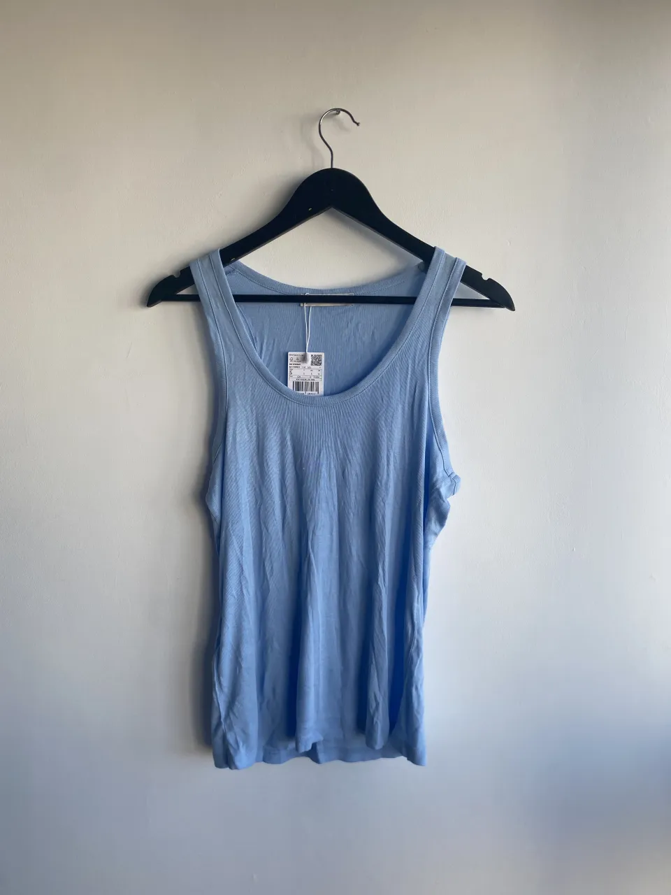 Musculosa de algodón color celeste. Tiene cuello redondo y breteles anchos.