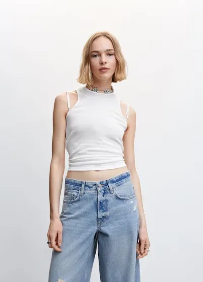 Top blanco de mujer, estilo musculosa con breteles finos y detalles en los hombros. Ideal para un look casual y moderno.