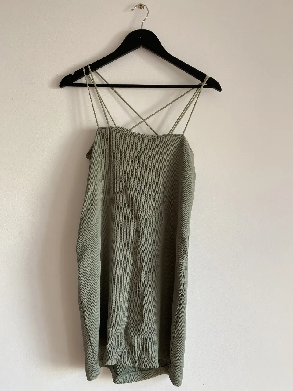 Vestido mini con tiras finas cruzadas en la espalda, ideal para el verano. Confeccionado en tela suave y fresca, perfecto para un look casual y cómodo.