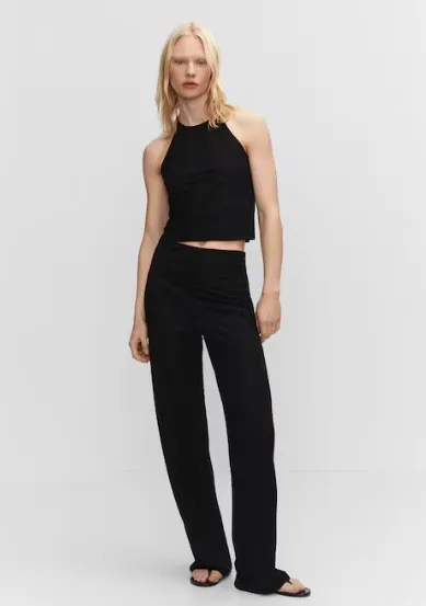 Top negro de corte halter, ideal para un look moderno y versátil. Combinalo con pantalones de vestir para un outfit elegante o con jeans para un estilo casual.